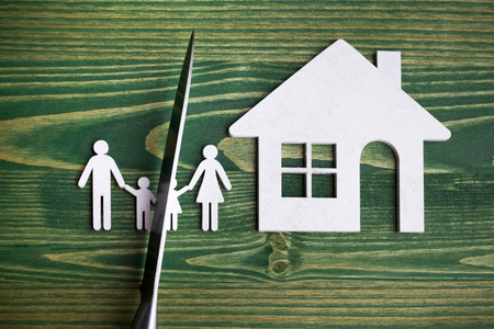 knife divides the whole family. divorce idea. wooden figure. wood background.の写真素材