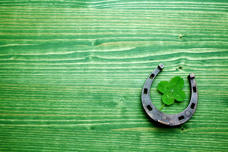 four-leaved clover and a horse shoe on green wooden background. St. Patricks dayの写真素材