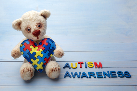 World Autism Awareness day, mental health care concept with teddy bear holding puzzle or jigsaw pattern on heartの写真素材