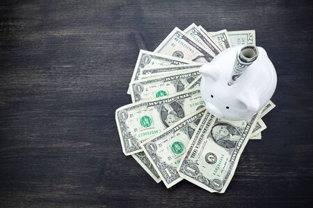 piggy bank with money on dark wooden backgroundの写真素材