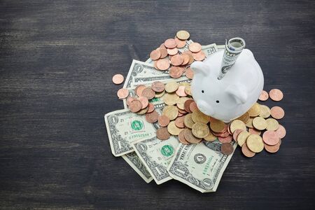 piggy bank with money on dark wooden backgroundの写真素材