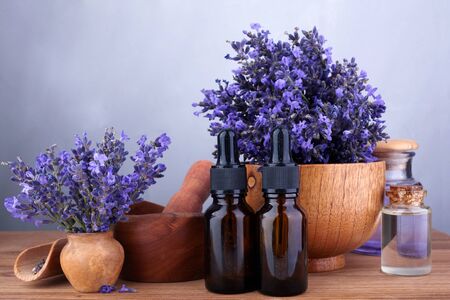 essential oil and lavender flowers on wooden tableの写真素材