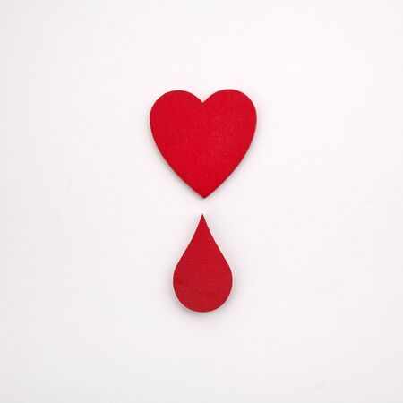 Giving blood saves live. Blood Donation concept. Red heart and blood drop on white backgroundの写真素材