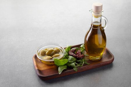 Olive oil basil and spices on the gray tableの写真素材