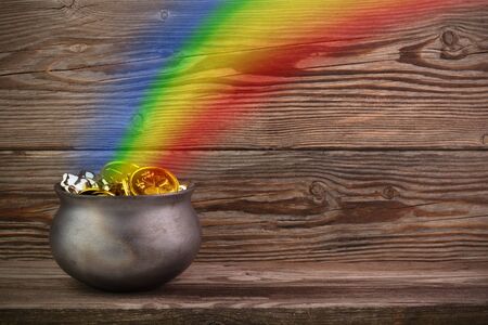 Rainbow pot of gold on old wooden background. St. Patricks day symbolの写真素材