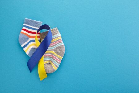 World Down syndrome day background. Down syndrome awareness concept. Socks and ribbon on blue backgroundの写真素材