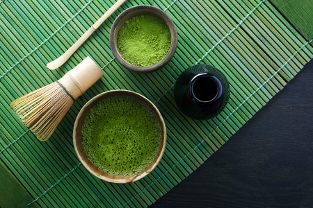 Matcha powder. Organic green matcha tea ceremony. Traditional japanese drink on black wooden...