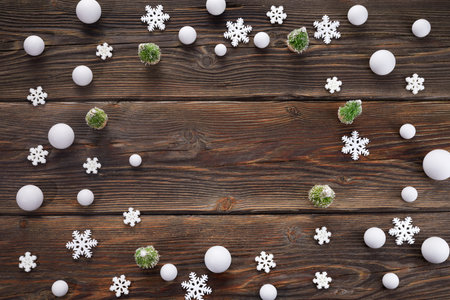 Snowflakes and snowballs frame on wooden background. Top view