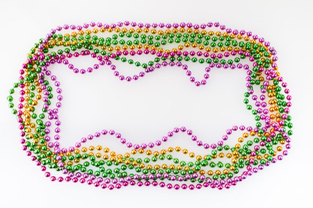 Three colors Mardi gras beads frame on white backgroundの写真素材