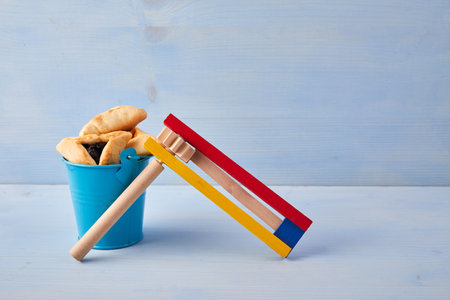 Purim celebration concept with hamantashen cookies, Purim toy noisemaker on blue backgroundの写真素材