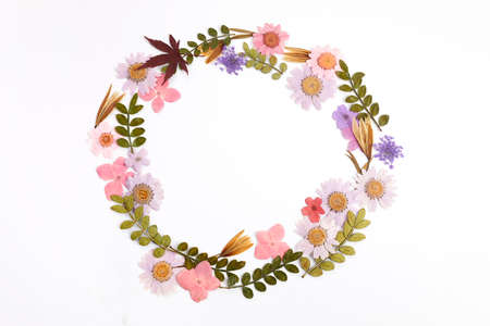 Wreath made from dry leaves and flowes on white background. Dry flowers frame. Flat lay.の写真素材