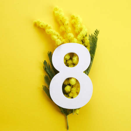 Greeting for International Womens Day on March 8th. Branches of mimosa and number eight.の写真素材