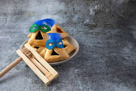 Purim celebration concept with hamantashen cookies, Purim mask and toy noisemaker on grey backgroundの写真素材