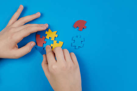 World Autism Awareness day, mental health care concept with puzzle or jigsaw pattern on heart with childs handsの写真素材