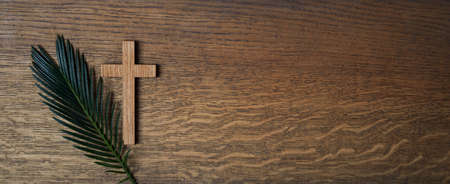 Palm sunday background. Cross and palm on wooden background.の写真素材