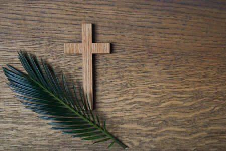 Palm sunday background. Cross and palm on wooden background.の写真素材