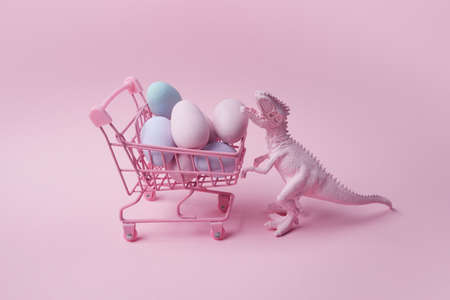 T rex dinosaur with shopping cart and eggs on pink background. Easter mega sale concept.の写真素材