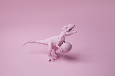 T rex dinosaur with easter egg on pink background. Funny Ester greating.の写真素材