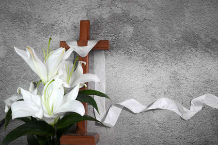 Cross with white lilies on grey background. Catolic Ester concept.の写真素材