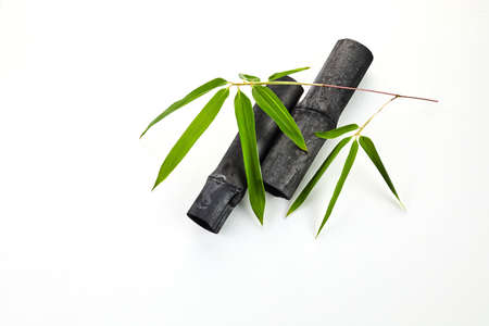 Natural bamboo charcoal stocks with leaves isolated on white backgroundの写真素材