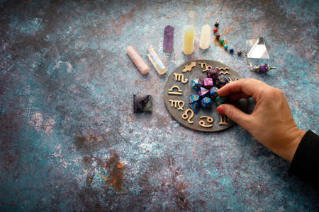zodiac horoscope symbol with fortune-teller hands and healing crystals on rustic backgroundの写真素材