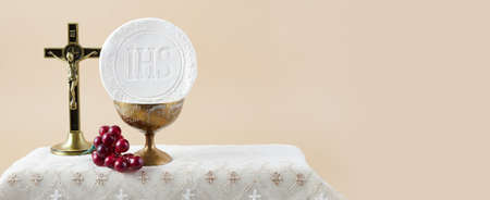 The Feast of Corpus Christi Concept. Holy communion and cup of glass with red wine on table.の写真素材