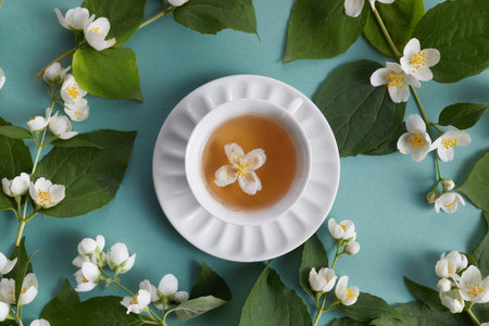 cup of tea with jasmine flowers on green background. Flat lay, top viewの写真素材