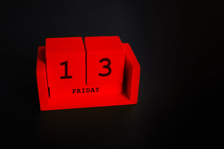 Friday 13 wooden blocks on black background.