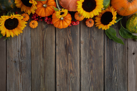 Thanksgiving framework. Flowers, pumpkins and fallen leaves on wooden background. Copy space for...