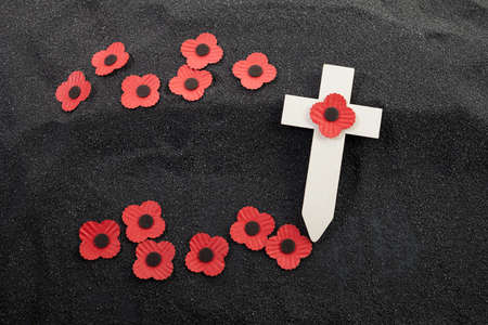 Remembrance Day poppy symbol on wooden cross. 11th November is a memorial day of the First World War.の写真素材