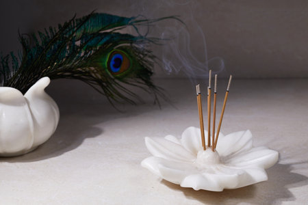 Smoke from burning incense sticks standing on lotus incense holderの写真素材