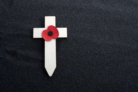Remembrance Day poppy symbol on wooden cross. 11th November is a memorial day of the First World War.の写真素材