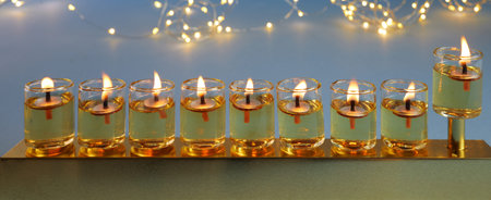 Jewish holiday Hanukkah background with menorah traditional candelabra and candles on blue...