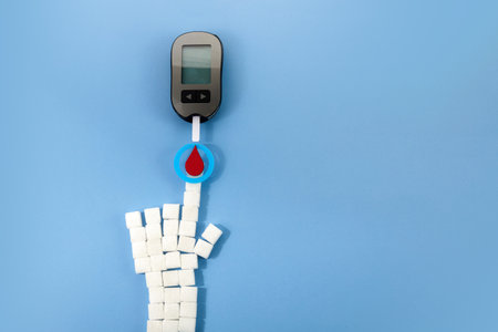 World diabetes day concept. Red blood drop in circle with Blood glucose test strip and Glucose meter. Top viewの写真素材