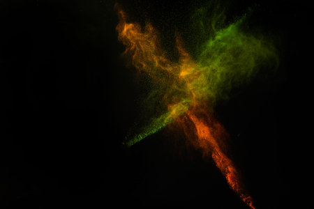 Freeze motion of colorful dust explosion on black background for Happy Holi
