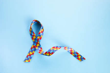 Autism awareness concept with colorful ribbon on blue background. Top viewの写真素材