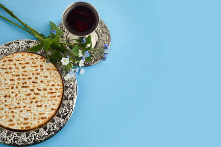 Pesah celebration concept, jewish Passover holiday. Matzah and red kosher. Traditional ritual Jewish bread on blue backgroundの写真素材
