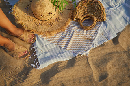 Top view of beach accessories. Straw hat, bag, flip flops on sand at beach.の写真素材