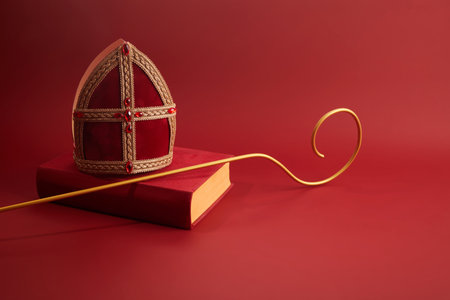 6th december Saint Nicholas Day - Sinterklaas. St Nicholas mitre and book on red table