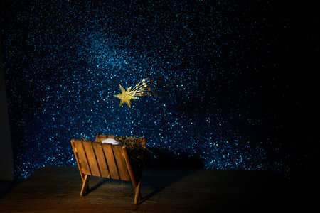 Nativity of Jesus, empty manger at night with bright lights.