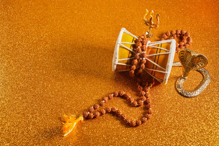 Shivaratri background with Shivas trident and Pellet Drum Damroo musical instrument . Hindu festival...