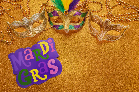 Mardi gras or carnival mask with beads on gold glowing background. Venetian mask.の写真素材