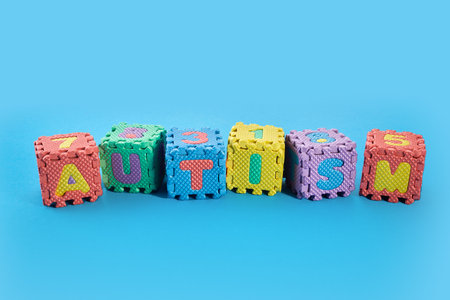 Word Autism on puzzle cubes on blue background.の写真素材