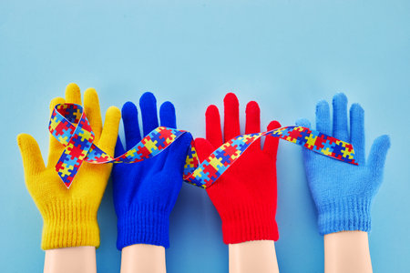 Hands holding puzzle ribbon for World Autism Awareness Day.の写真素材