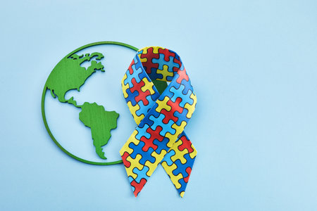 World Autism awareness and pride day or month with Puzzle pattern ribbon on blue backgroundの写真素材