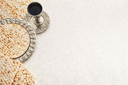 Passover celebration concept. Traditional ritual Jewish bread Matzah and red kosher on sand color background. Passover food.の写真素材