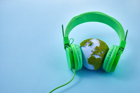 World music day concept. Stereo headphone and a globe on a blue backgroundの写真素材