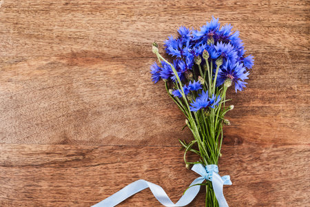 Blue cornflowers, bouquet picked in summer on wooden background.
