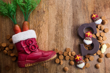 Dutch holiday Sinterklaas background. Children shoe with carrots, traditional sweets and chocolate letterの写真素材