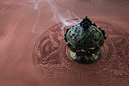 Smoke from burning incense sticks on brown decorative backgroundの写真素材